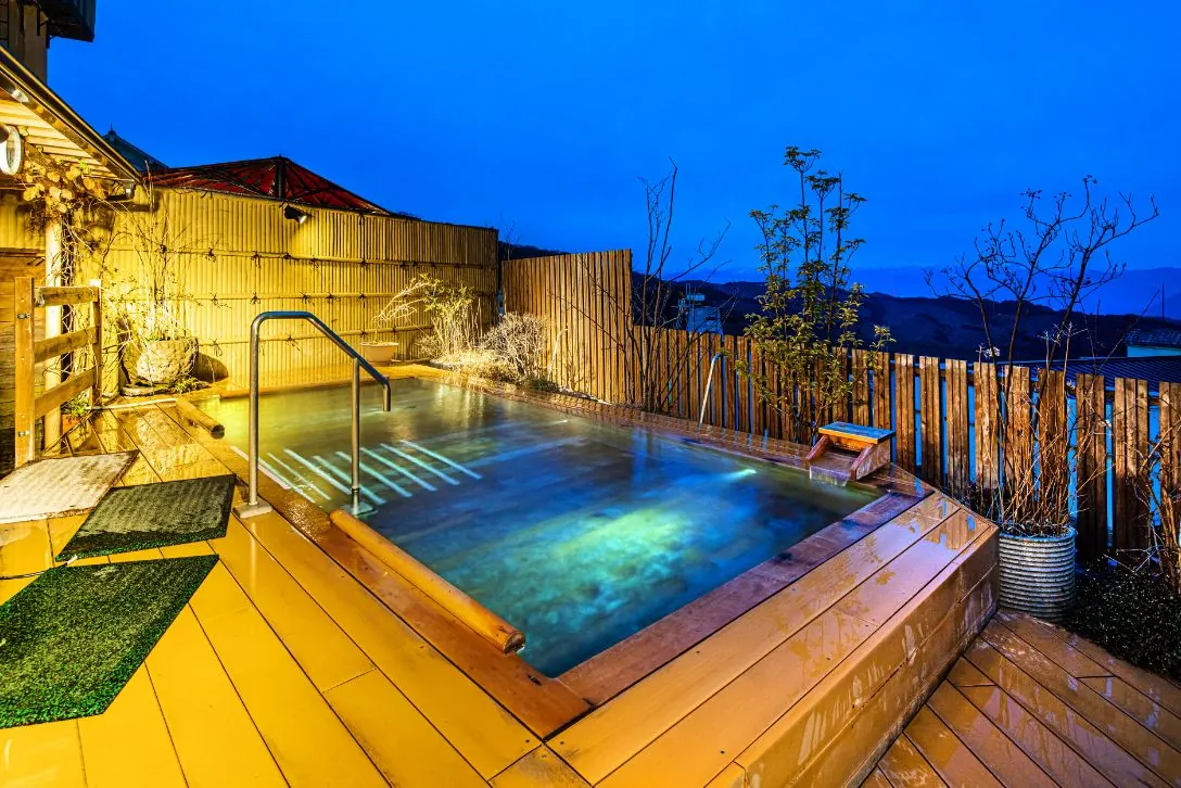 Rooftop open-air bath at night overlooking Ikaho