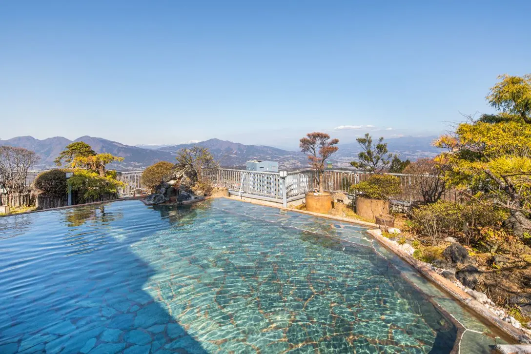 Rooftop open-air bath in daylight with mountain views